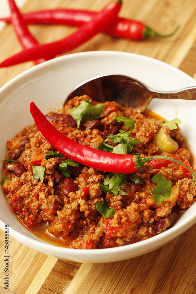 Chilli with minced beef and herbs on white bowl Chilli with minced beef and herbs on white bowl
