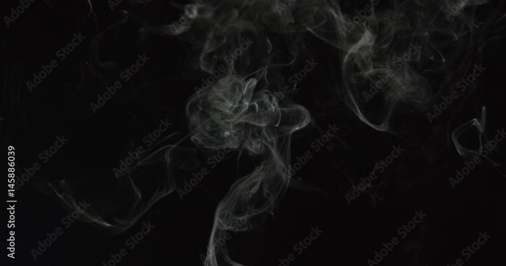 Curling billows of smoke shoot from bottom and fill frame, rising against black Curling billows of smoke shoot from bottom and fill frame, rising against black