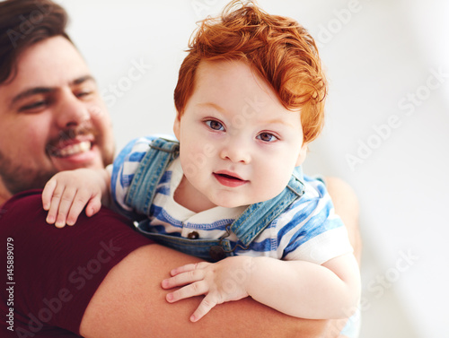 Billede på lærred portrait of adorable red head infant baby boy on father's hand