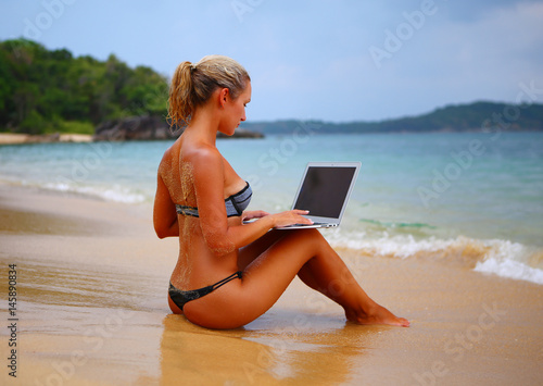 Girl with laptop on the beach