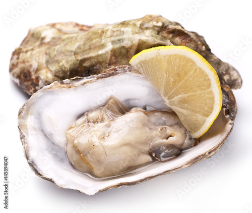 Raw oyster and lemon on a whte background.