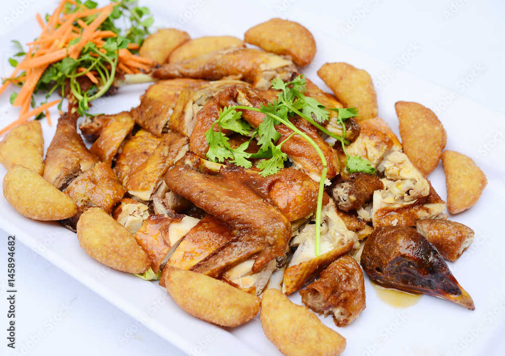 Chopped fried chicken with potatoes and herbs on white platter Chopped fried chicken with potatoes and herbs on white platter
