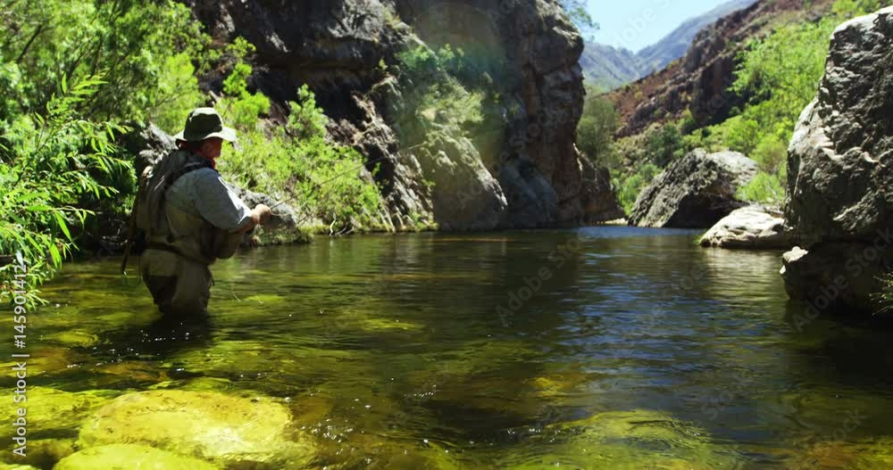 Fisherman fly fishing in river