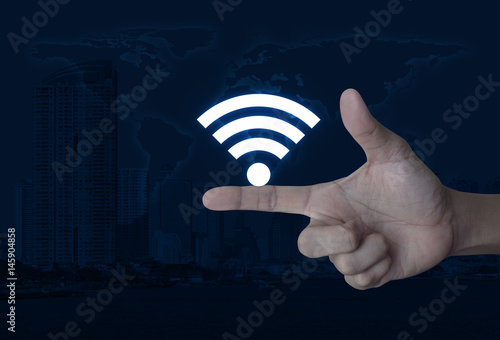 Wifi icon on finger over world map and modern city tower, Technology and internet concept, Elements of this image furnished by NASA