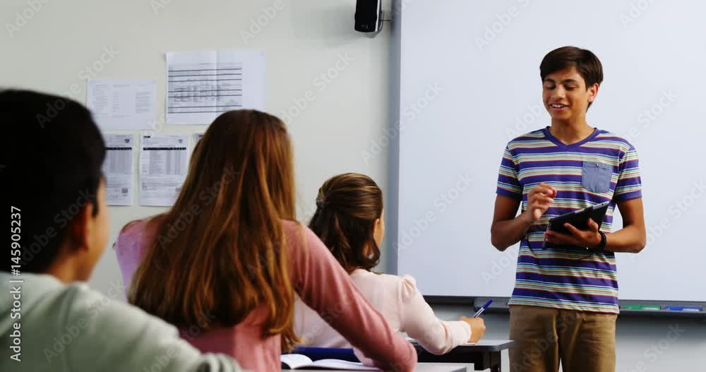 Mixed race school boy giving presentation in classroom