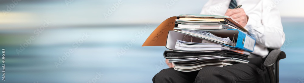 Businessman working with folders on his lap Businessman working with folders on his lap
