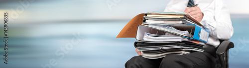 Businessman working with folders on his lap