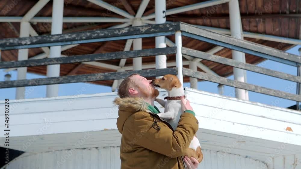 man throws dog Jack Russell in the background of the lighthouse man throws dog Jack Russell in the background of the lighthouse