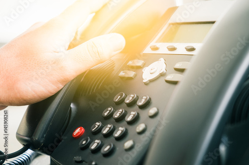Set of black telephones on a desk, receiver close-up.
