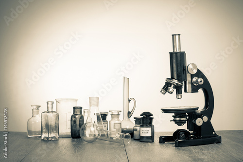 Old laboratory glass and retro microscope vintage sepia photo