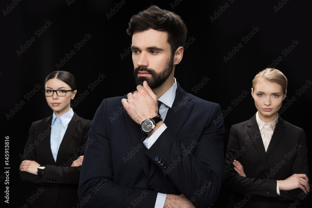 pensive business people standing with crossed arms isolated on black, business establishment concept pensive business people standing with crossed arms isolated on black, business establishment concept