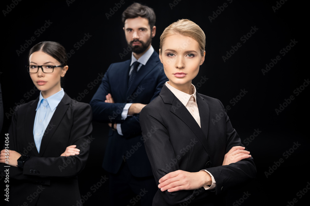 business team standing with crossed arms isolated on black, business establishment concept business team standing with crossed arms isolated on black, business establishment concept