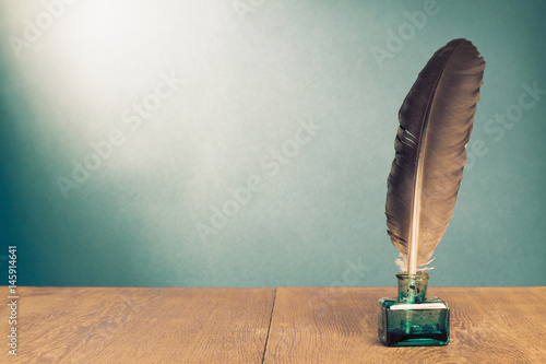 Fotografia Vintage background with quill pen, inkwell on wooden table