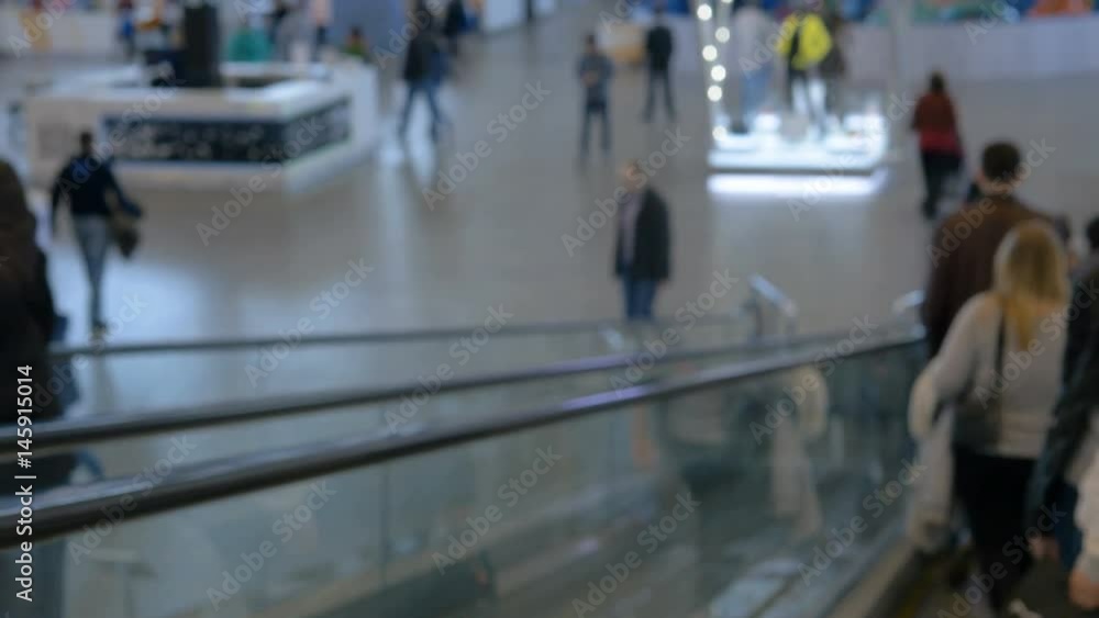 Buyers go down and climb the escalator in the mall. Blurred intentionally. Buyers go down and climb the escalator in the mall. Blurred intentionally.