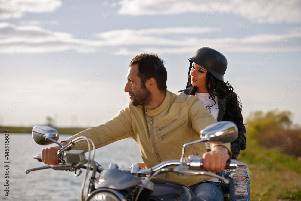 Beautiful young couple with a classic motorcycle
