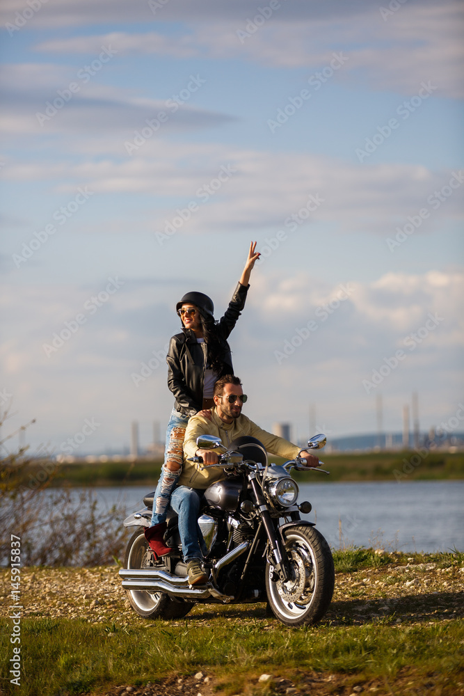 Beautiful young couple with a classic motorcycle Beautiful young couple with a classic motorcycle