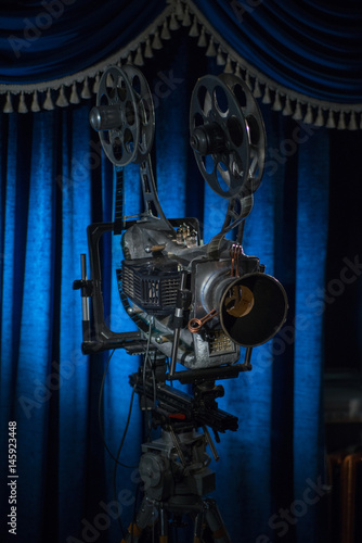 Film projector on a background of blue curtains