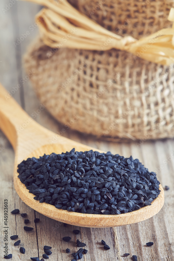 Black cumin seed (Nigella sativa) in wooden spoon Black cumin seed (Nigella sativa) in wooden spoon