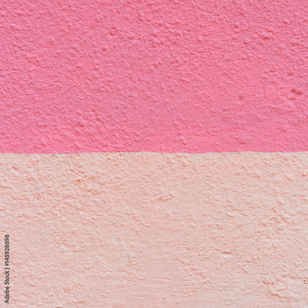 Fototapeta premium The wall of an old house of two shades of pink. Texture of the peeled surface.