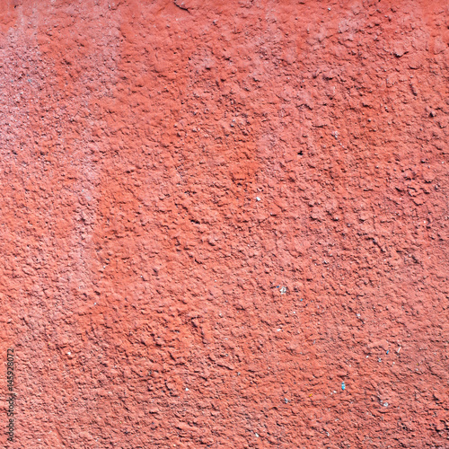 The old wall of the apartment house is red. Texture of the peeled surface.