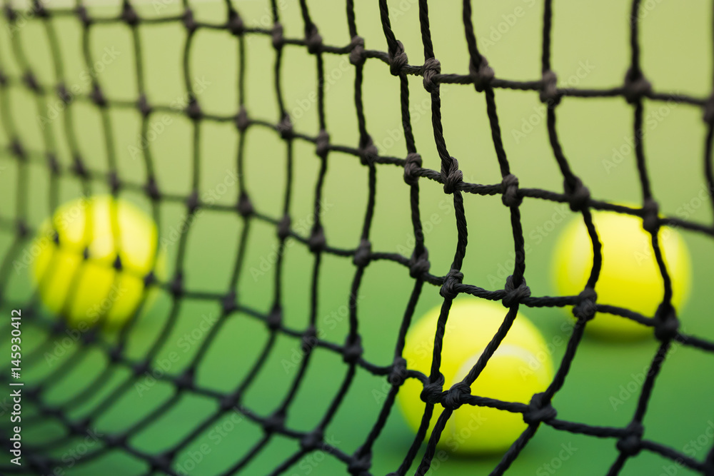 net of tennis in green court, three balls in background, blurred net of tennis in green court, three balls in background, blurred