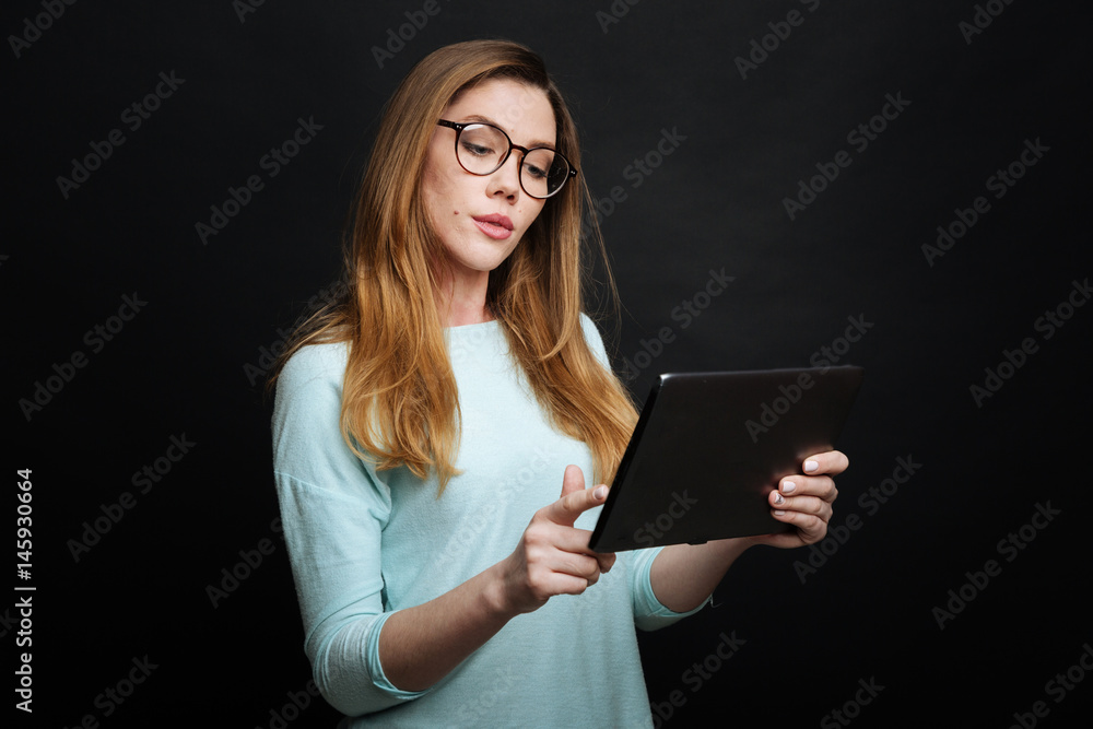 Smart young woman using modern tablet in the studio Smart young woman using modern tablet in the studio