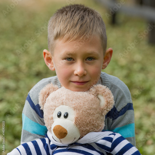 Portrait of a little boy with a toy outdoors.