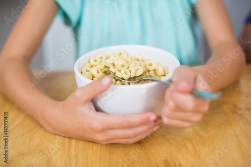 Girl having breakfast cereal in kitchen