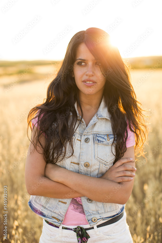 Portrait of a natural woman. She is wearing a denim jacket and white pants. Portrait of a natural woman. She is wearing a denim jacket and white pants.