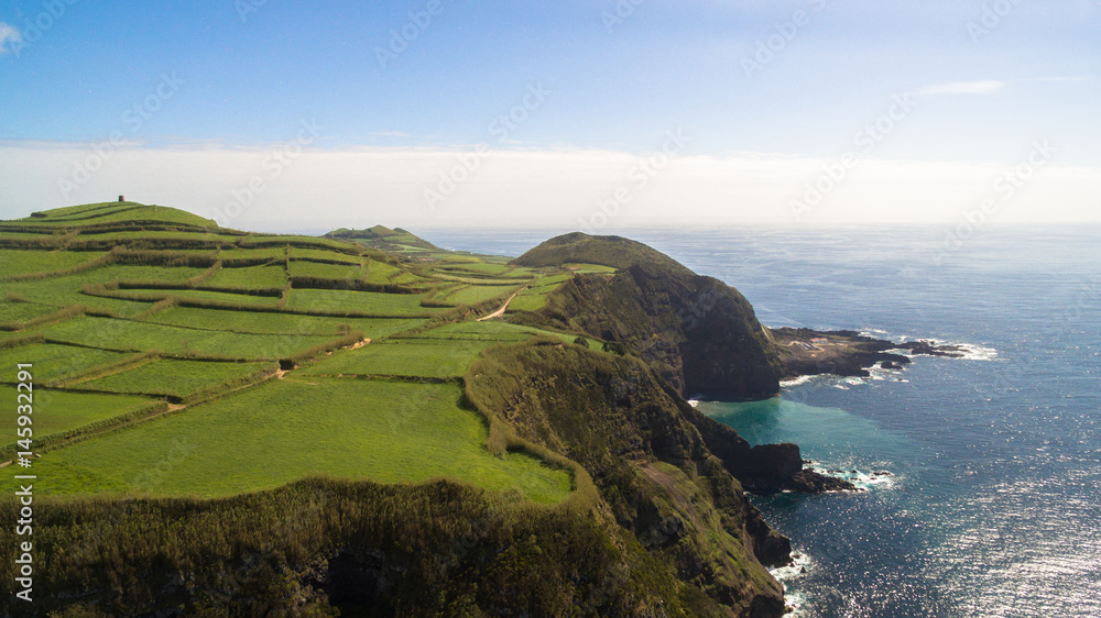 Green fields of Azores with atlantic ocean on background