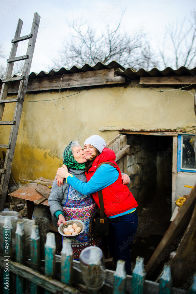 The young woman embraces the old woman. The young woman embraces the old woman.