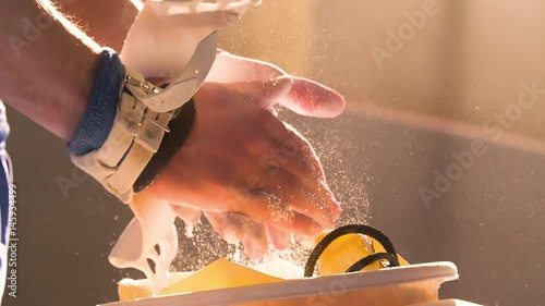 Athlete chalking hands wearing gymnastic grips before training HD video. Close-up view of gymnast hand