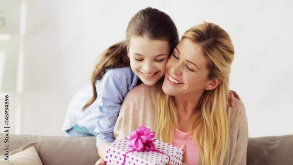 happy girl giving present to mother at home happy girl giving present to mother at home