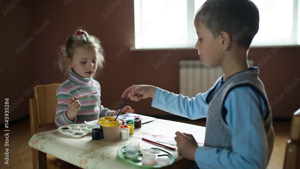 Children in nursery sitting at table drawing pictures. Children in nursery sitting at table drawing pictures.