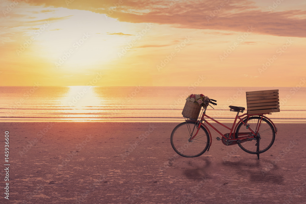 Fototapeta premium Bicycle on the beach with sunrise sky background, slow life concept