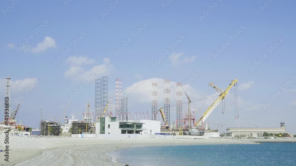 Panorama of Dubai cargo port, UAE HD slow-motion video. Shipping containers terminal, dock cranes, storage in shore sea beach Panorama of Dubai cargo port, UAE HD slow-motion video. Shipping containers terminal, dock cranes, storage in shore sea beach