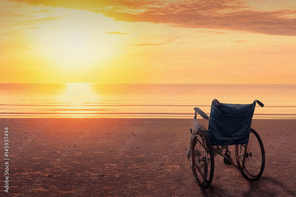 Wheelchairs parked on the beach at sunset time, in a lonely atmosphere.