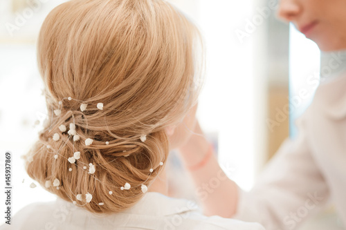 Hairdresser finishing bride's hairsyle