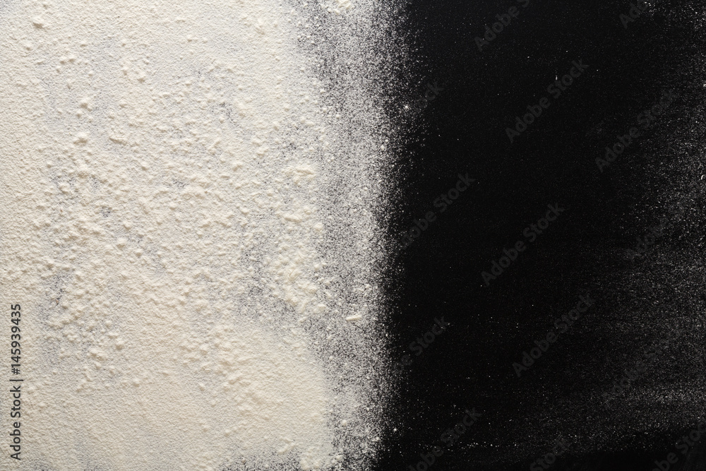 Baking concept on black background, sprinkled flour with copy space Baking concept on black background, sprinkled flour with copy space