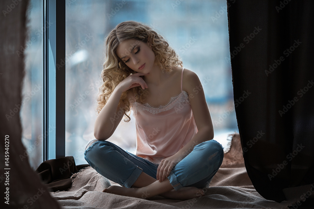 Beautiful girl sitting near the window Beautiful girl sitting near the window