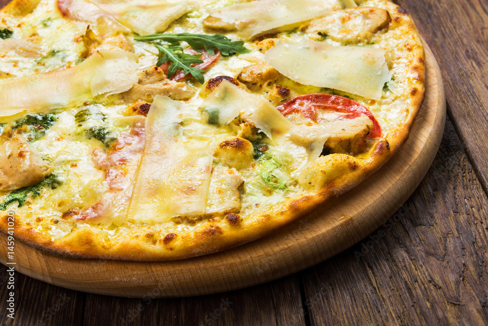 Delicious pizza with chicken, parmesan and fresh arugula