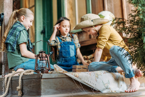 Cuadro en lienzo cute kids playing treasure hunt with map on porch