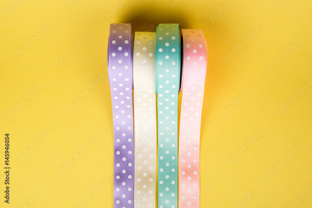 Closeup of ribbon roll over colorful background Closeup of ribbon roll over colorful background