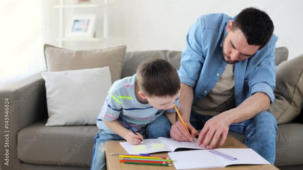father and little son with crayons drawing at home father and little son with crayons drawing at home