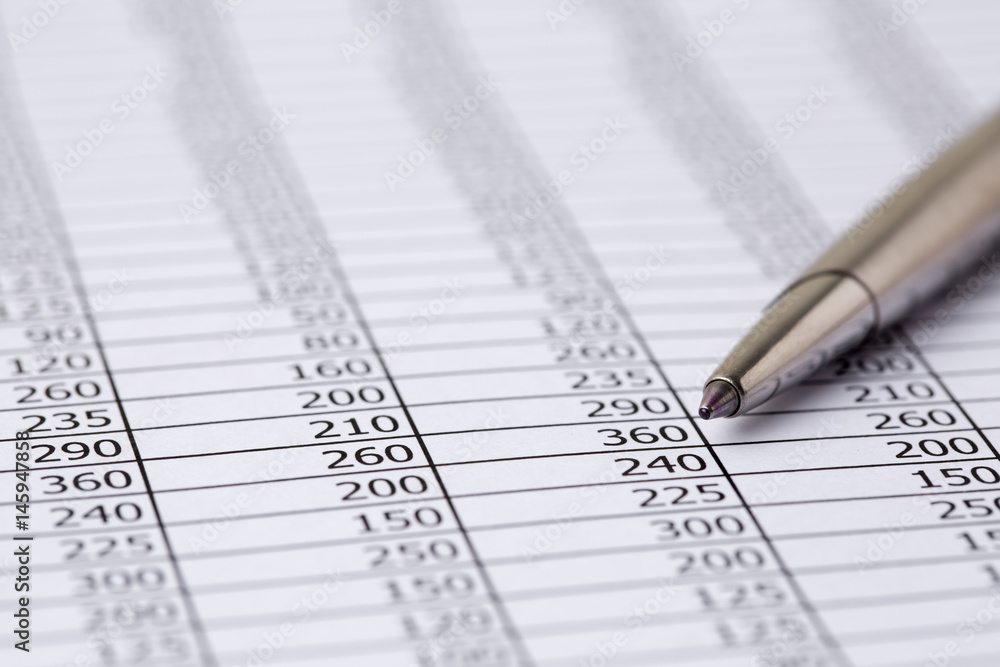 Close up a silver pen on financial accounting and marketing table analysis Close up a silver pen on financial accounting and marketing table analysis