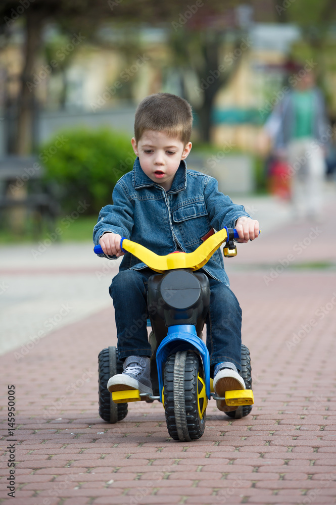 little boy ride toy motorcycle on sidewalk little boy ride toy motorcycle on sidewalk