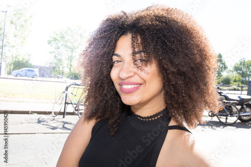 pretty mixed american woman in tonw with large smile photo