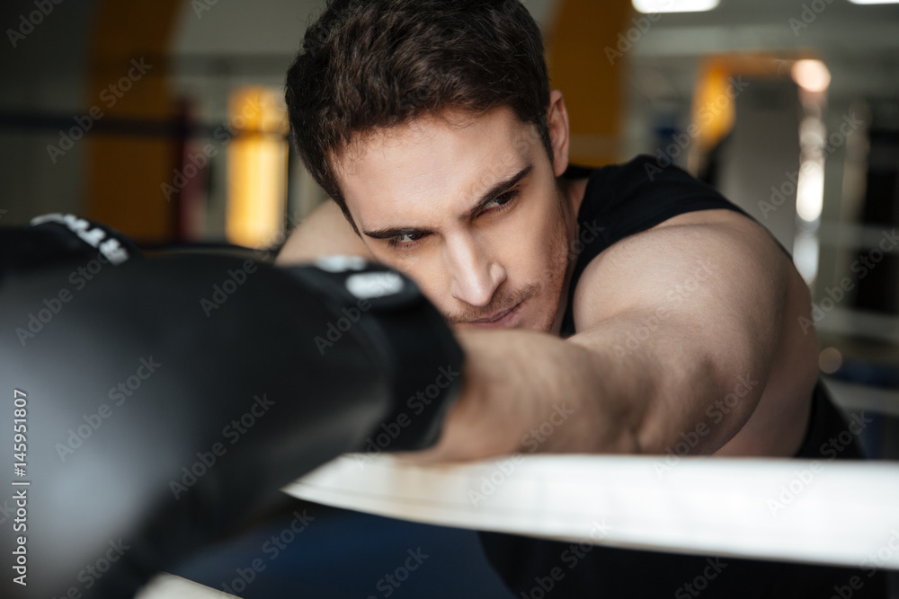 Tired sportsman after training leaning on ring Tired sportsman after training leaning on ring