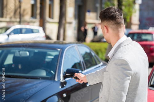Wallpaper Mural Man hand press the remote control car alarm systems Torontodigital.ca
