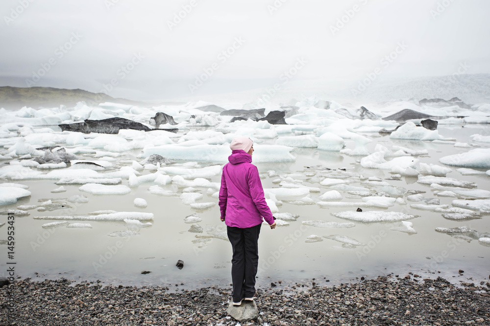 Young woman enjoying beautiful Jokulsarlon glacial lagoon, Iceland.